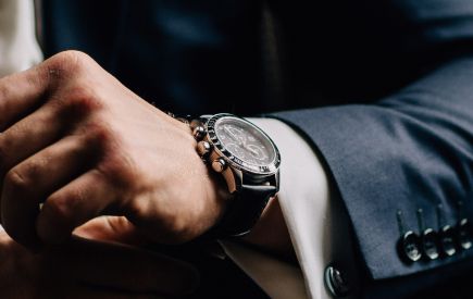 Nahaufnahme einer Uhr am Handgelenk eines Mannes im Anzug
